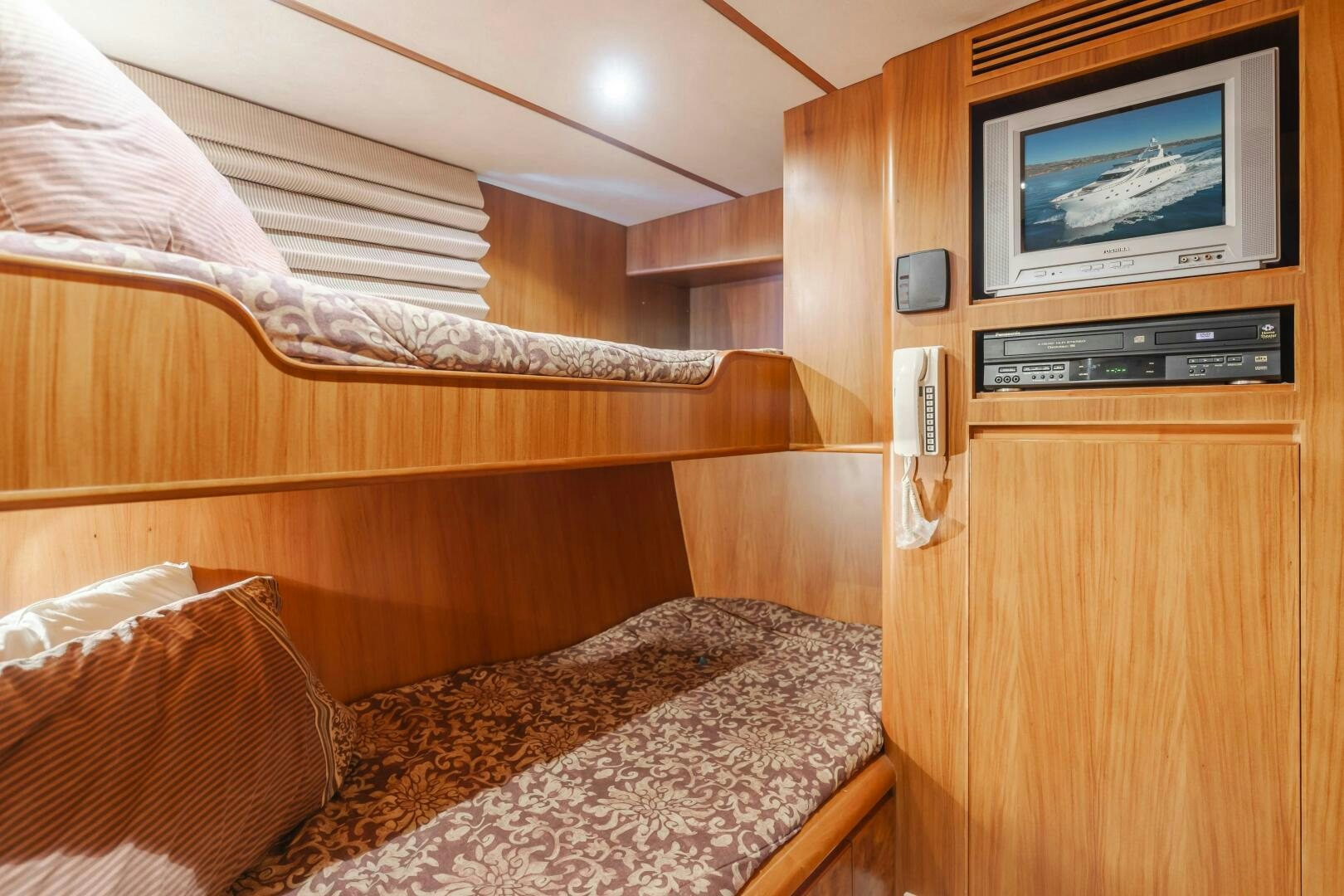 a bed with a television on the wall aboard MONEY CAT Yacht for Sale