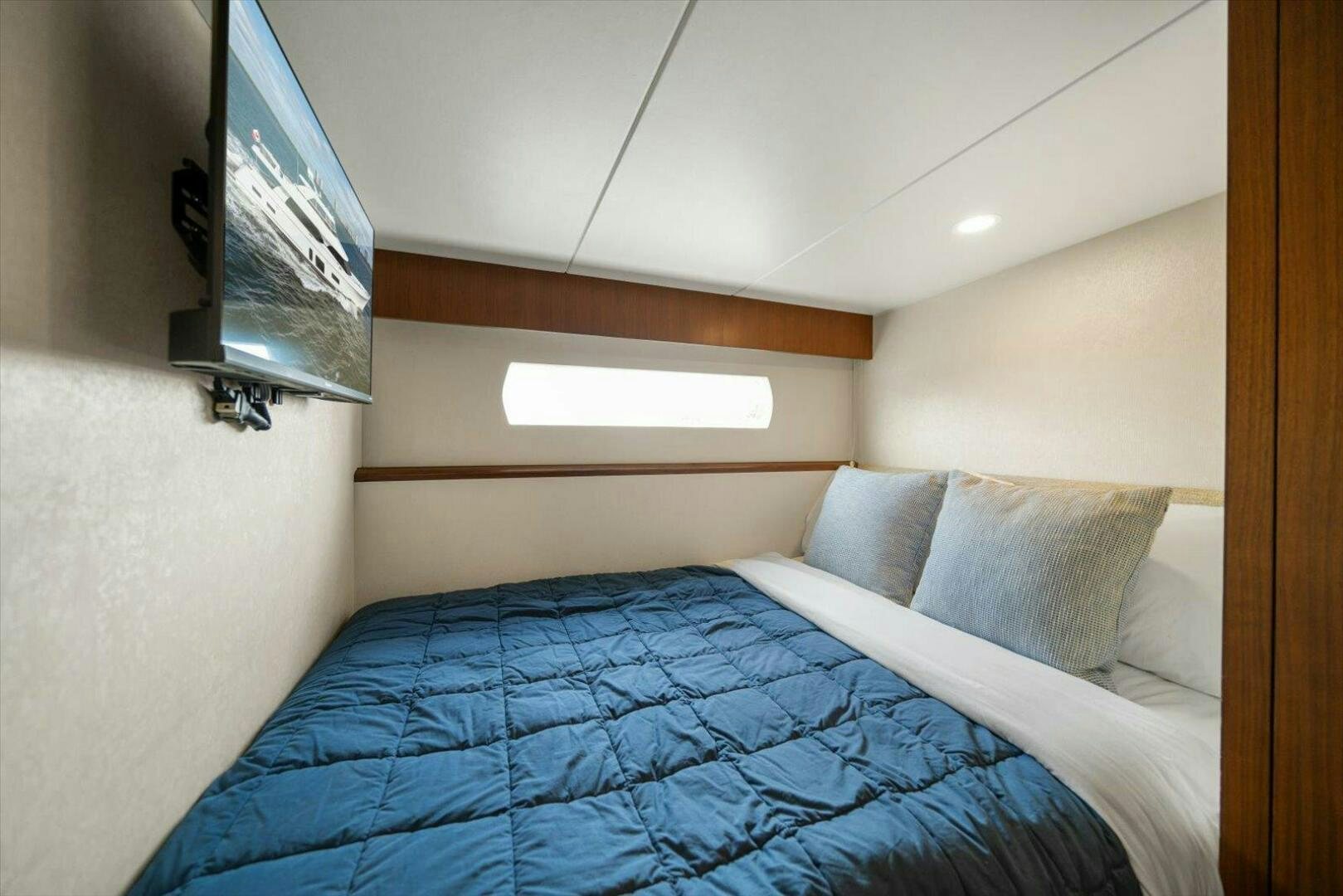 a bed with a blue comforter aboard CAROL ELAINE Yacht for Sale