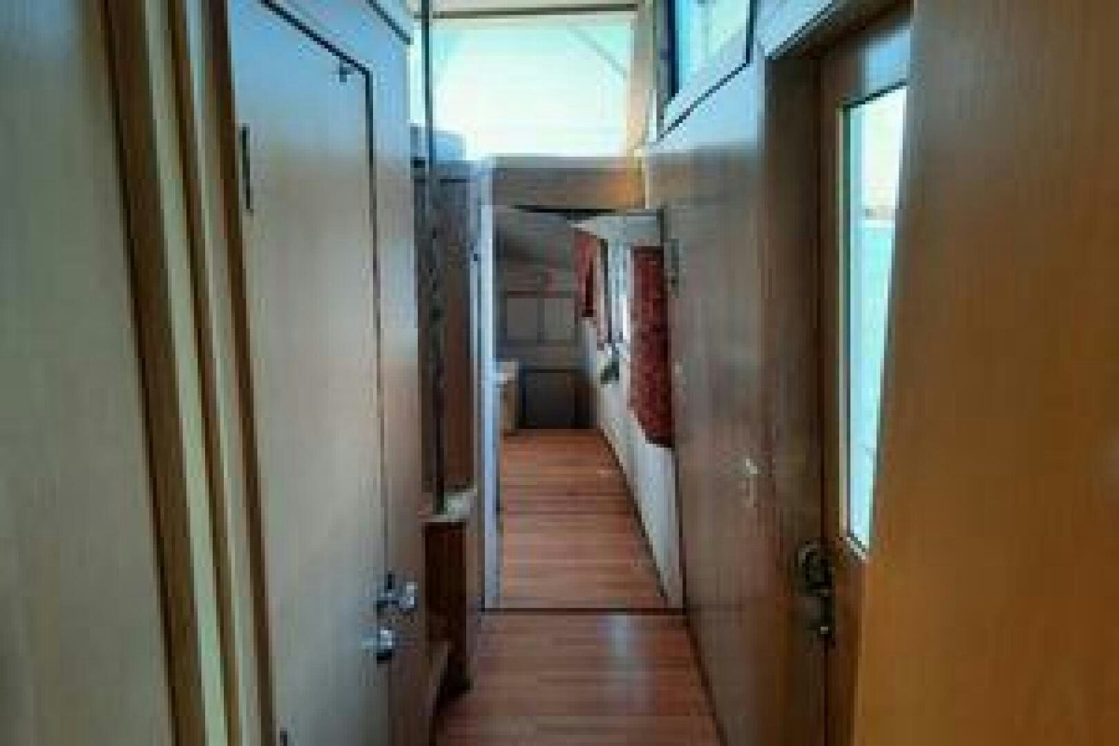 a hallway with a wood floor and a door with a window aboard URBAN LEGEND Yacht for Sale