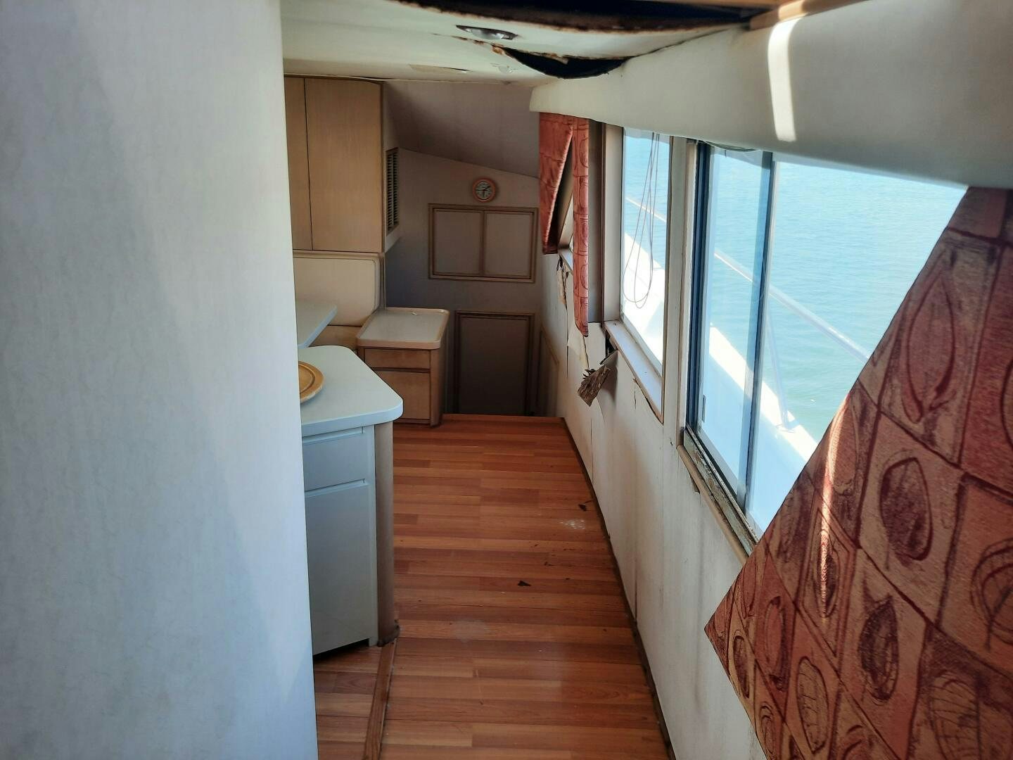 a hallway with a wood floor and a window with a red and white wall aboard URBAN LEGEND Yacht for Sale