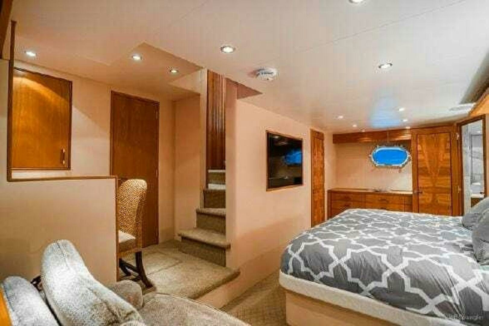 a bedroom with a bed and a television aboard DESPERADO Yacht for Sale