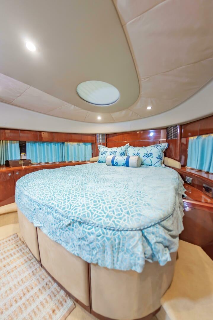 a bed with a blue and white comforter and a white pillow aboard ANDREA'S REVENGE Yacht for Sale