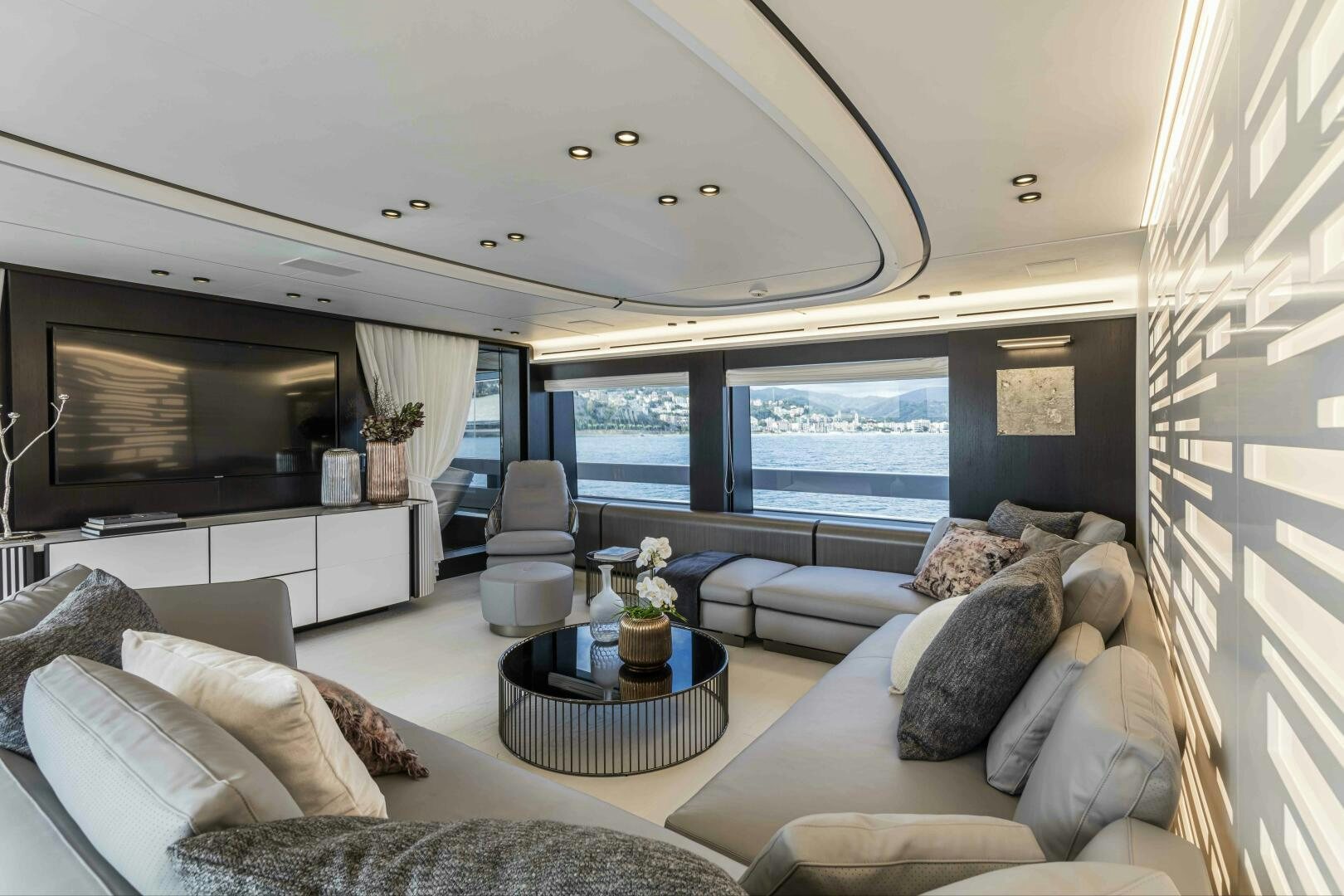 a living room with a large window aboard X130 TRIPLEX Yacht for Sale