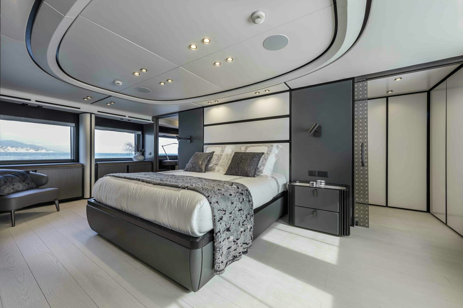 a bedroom with a bed and a large mirror aboard X130 TRIPLEX Yacht for Sale