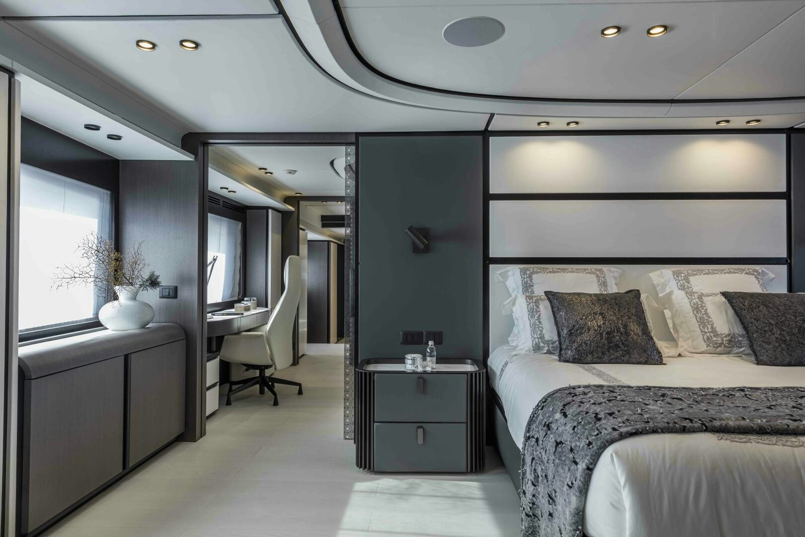 a bedroom with a bed and a desk aboard X130 TRIPLEX Yacht for Sale