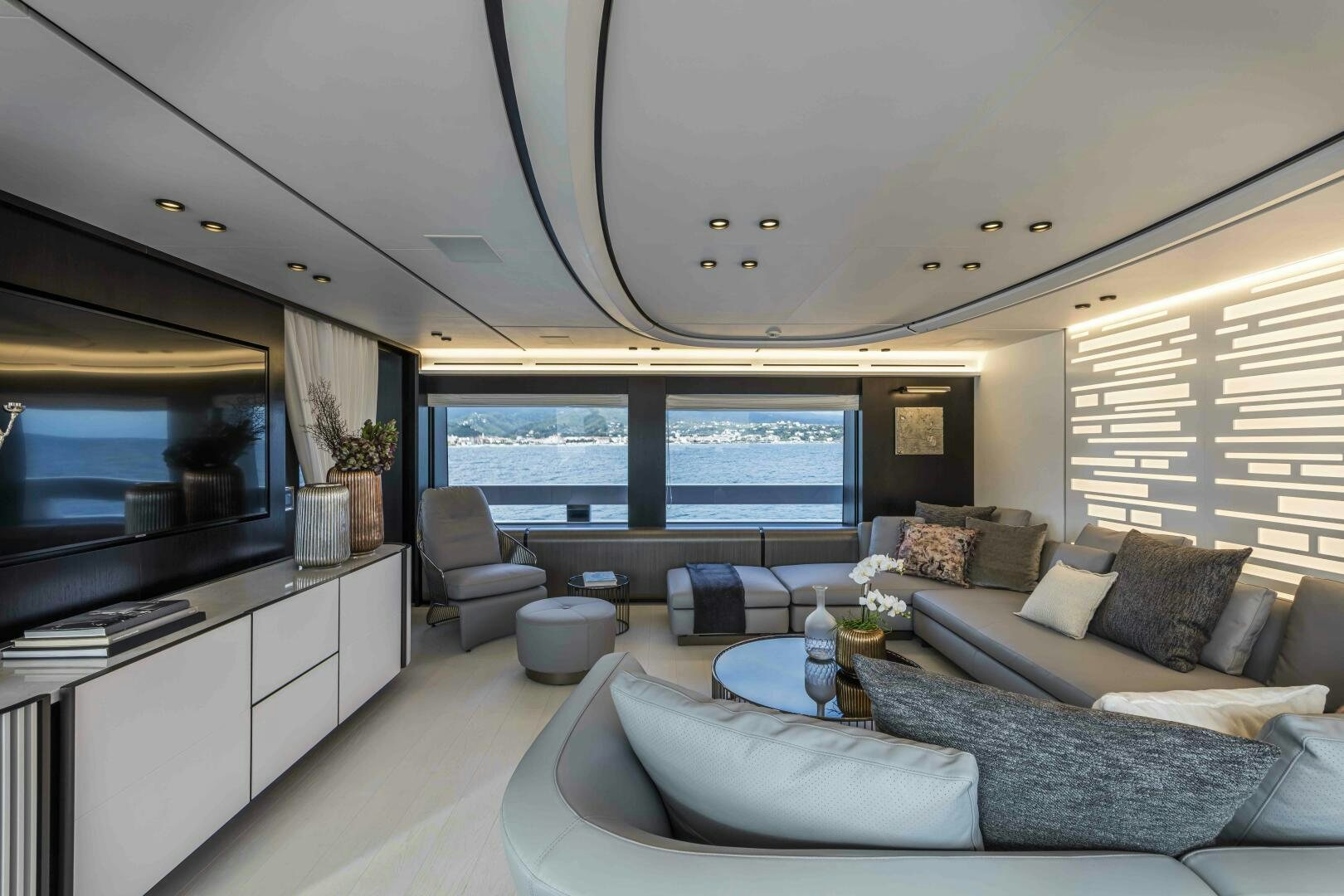 a living room with a large window aboard X130 TRIPLEX Yacht for Sale