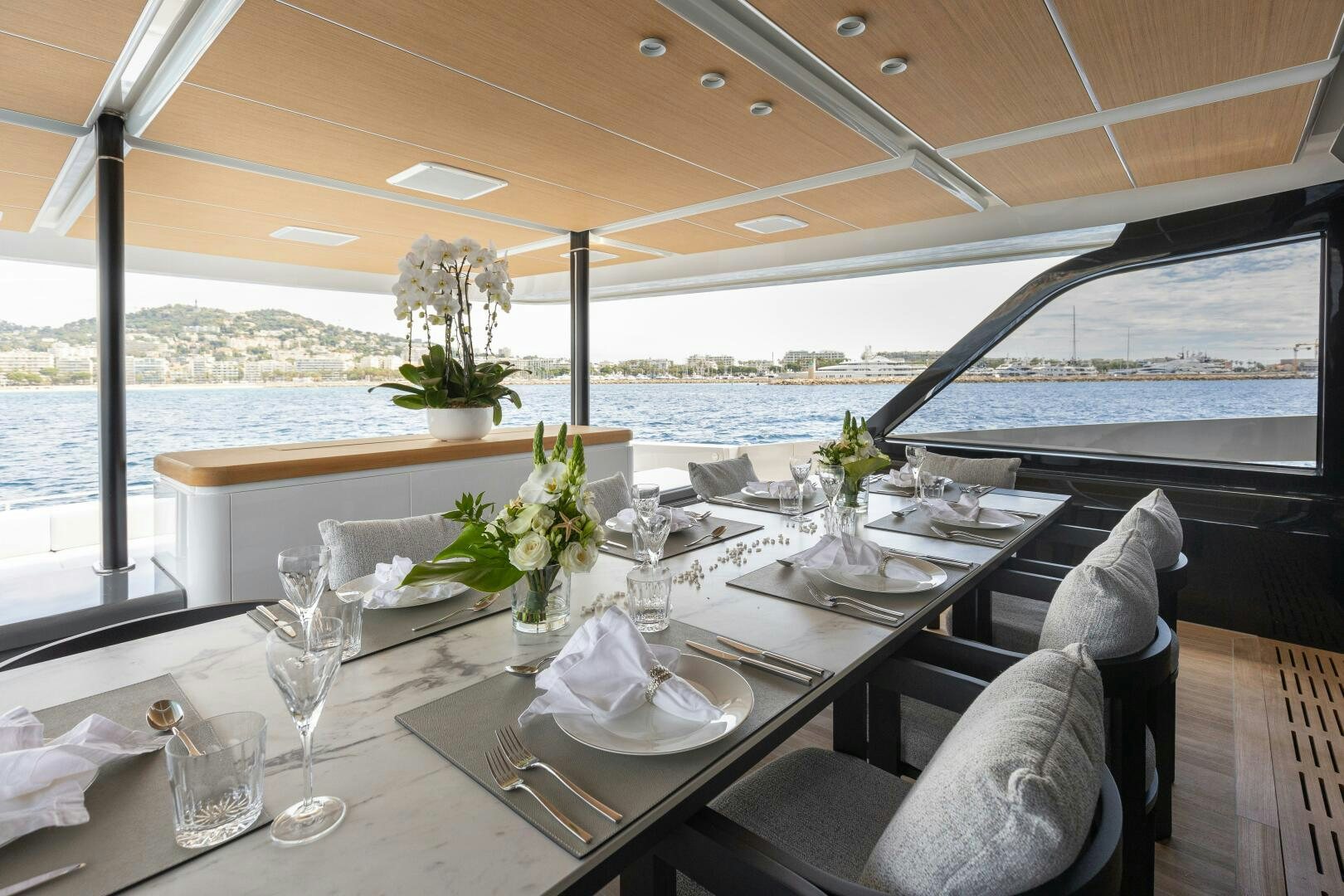 a table with chairs and plants on it aboard X99 FAST Yacht for Sale
