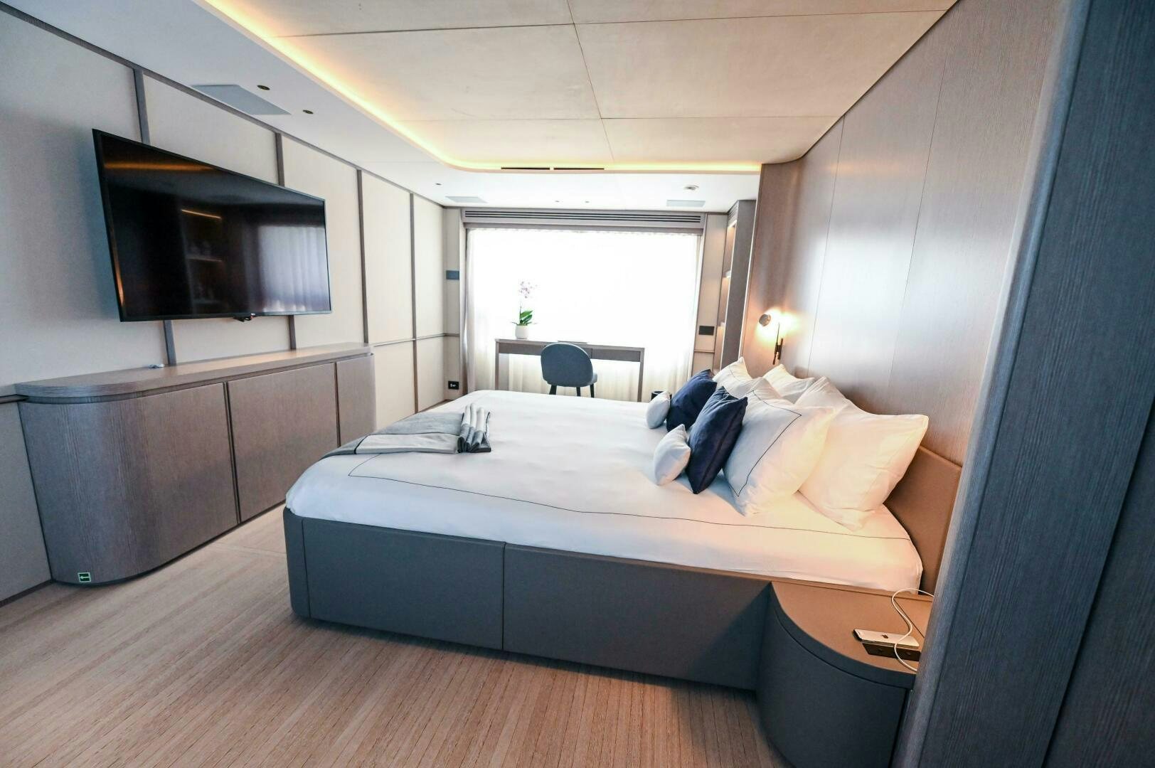 a bedroom with a bed and a television aboard SEAESTA Yacht for Sale