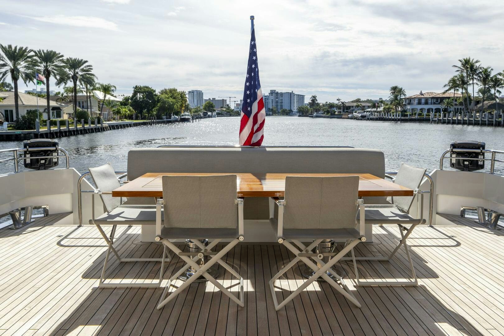 a deck with chairs and a flag on it aboard SEABISCUIT Yacht for Sale