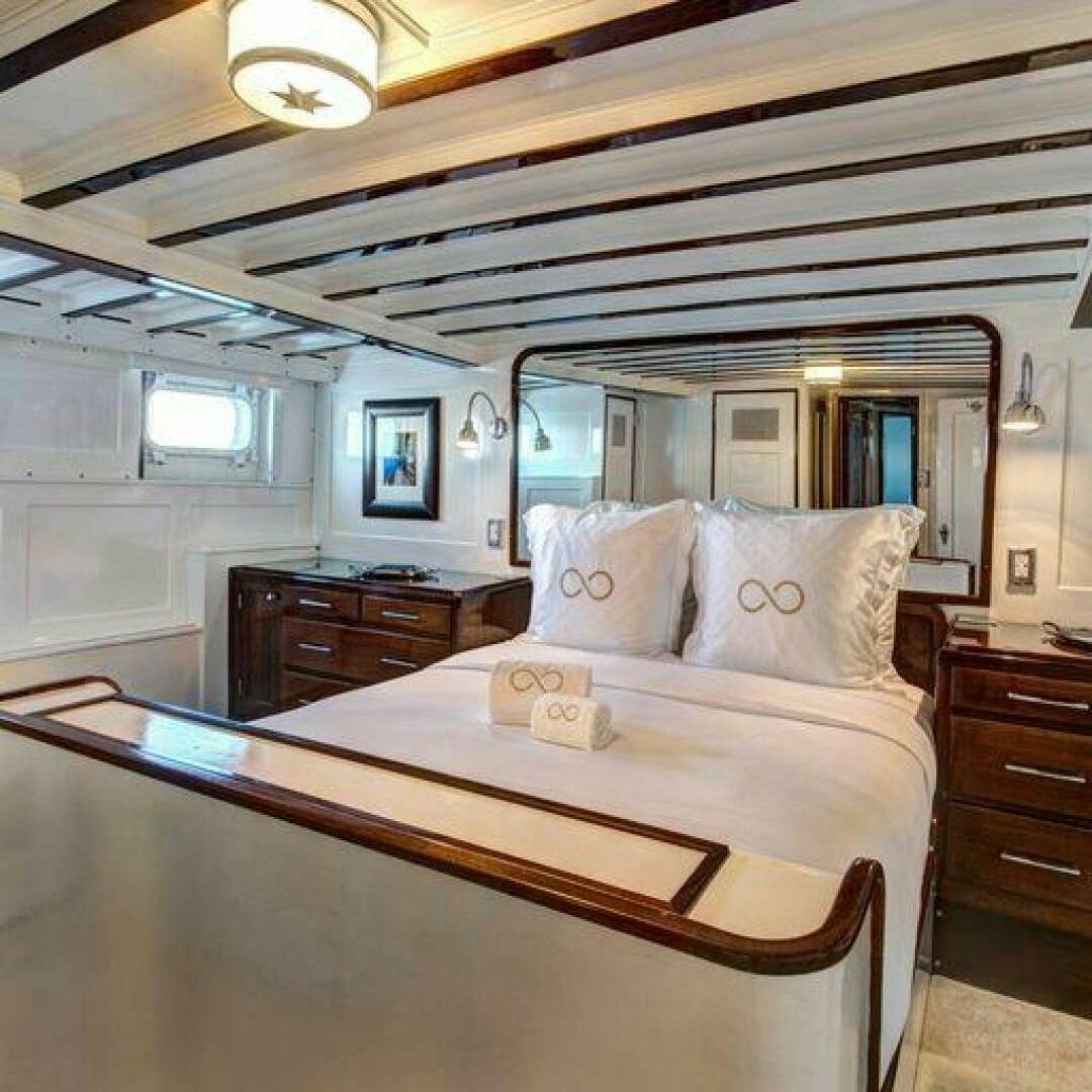 a bed with a white comforter aboard TIMELESS Yacht for Sale