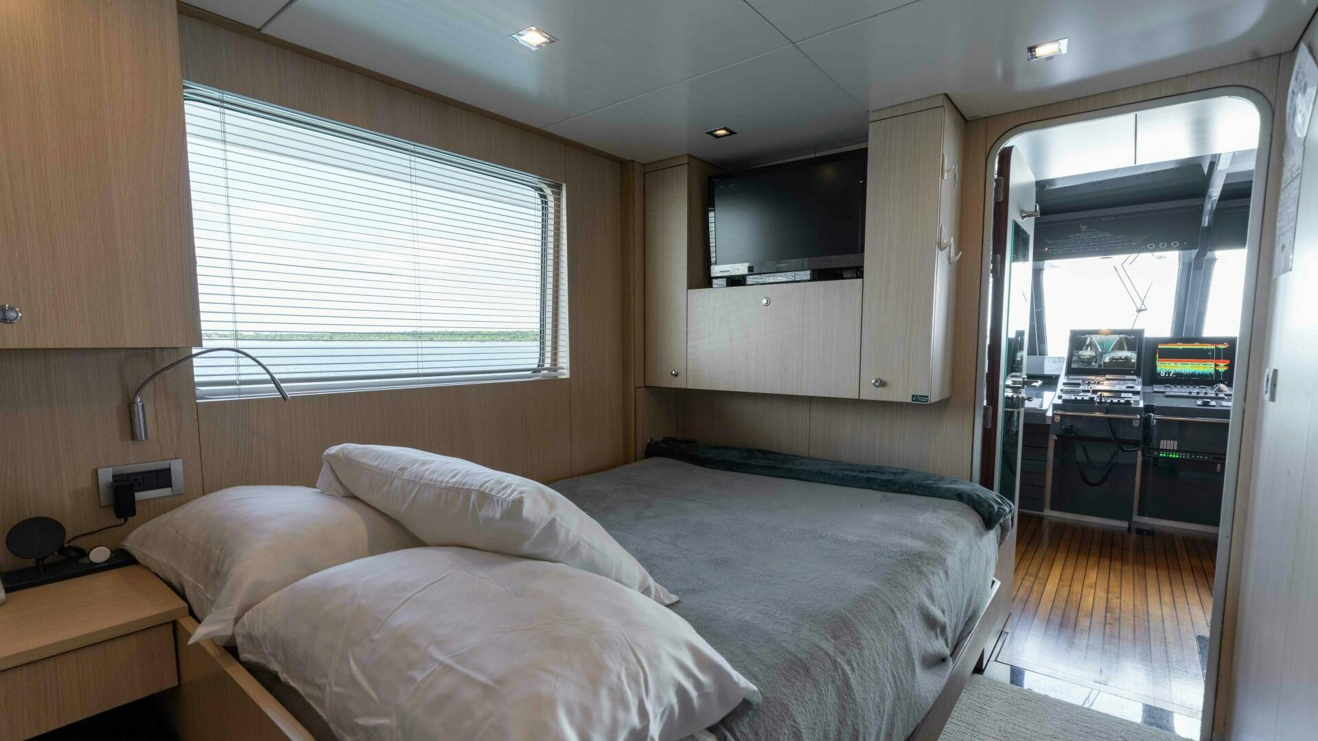 a bedroom with a bed and a desk aboard SEA AXIS Yacht for Sale
