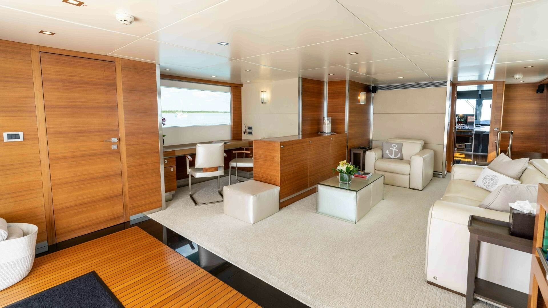 a living room with a large wood cabinet and white couches aboard SEA AXIS Yacht for Sale