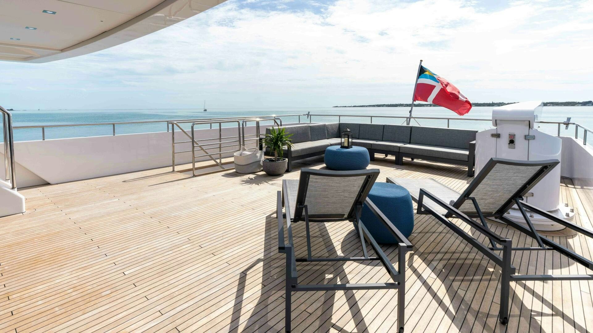 a deck with chairs and a flag aboard SEA AXIS Yacht for Sale
