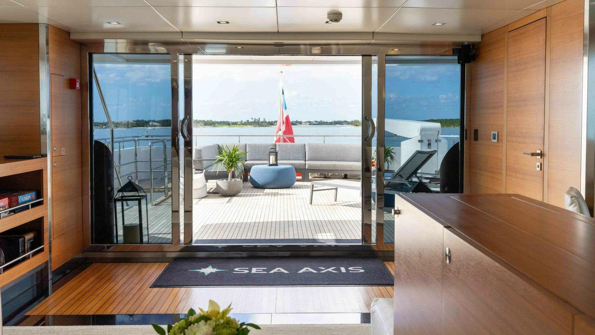 a room with a large window and a table with a chair and a boat in the water aboard SEA AXIS Yacht for Sale