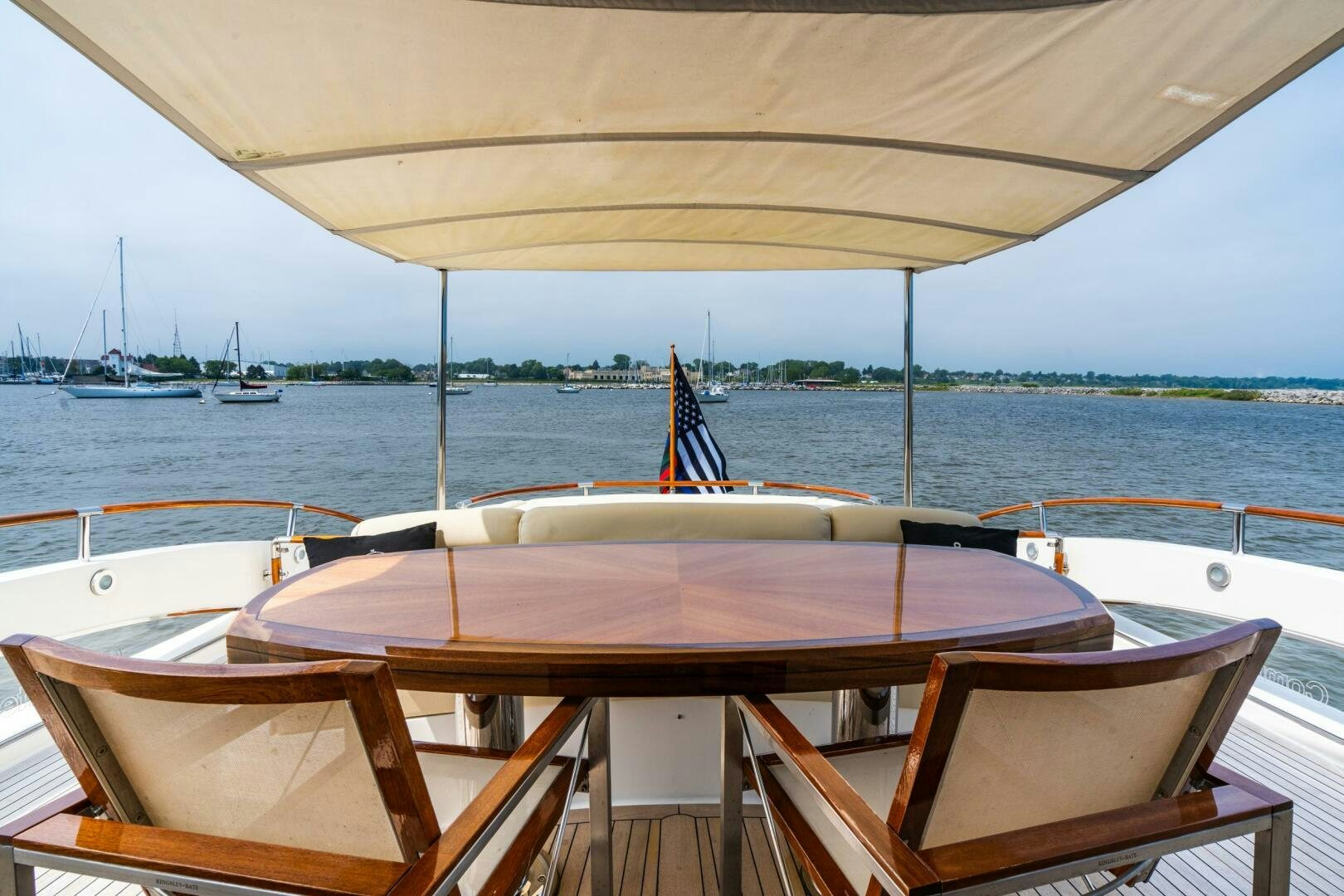 a table with chairs on it by a body of water aboard COMMITTED Yacht for Sale