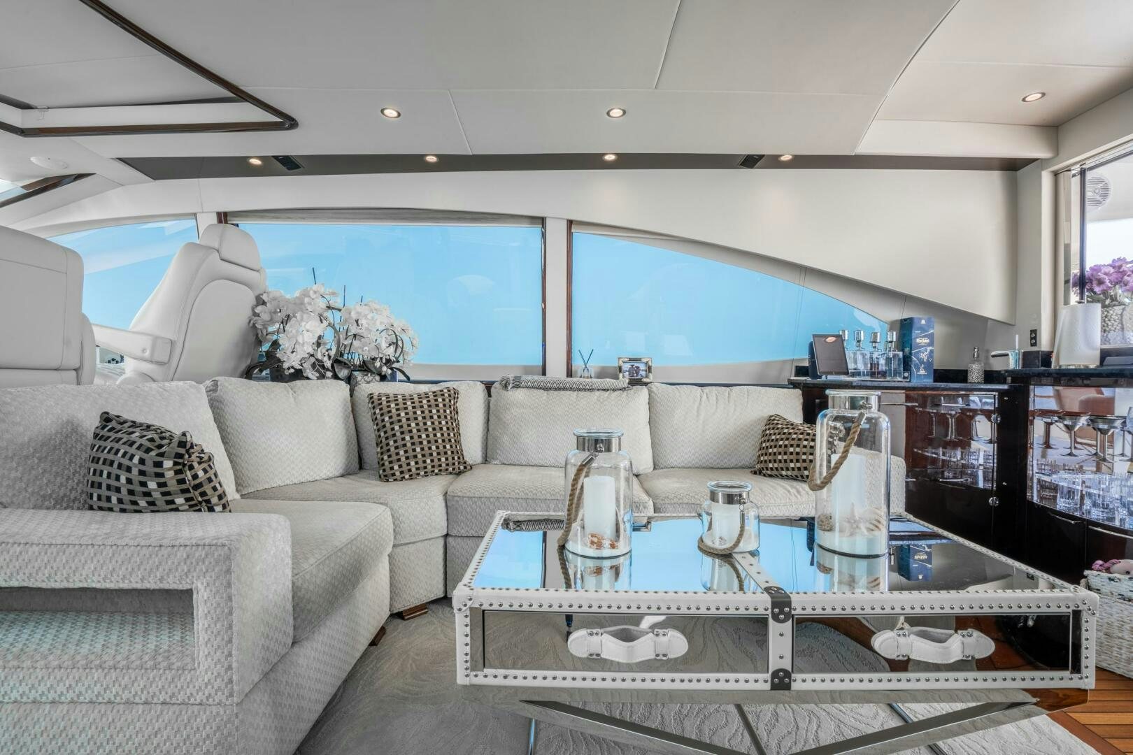 a living room with a large glass table and white couches aboard COMMITTED Yacht for Sale