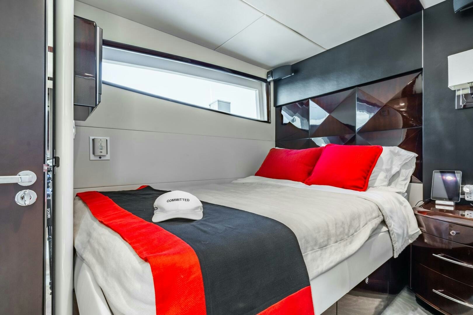 a bed with red pillows aboard COMMITTED Yacht for Sale