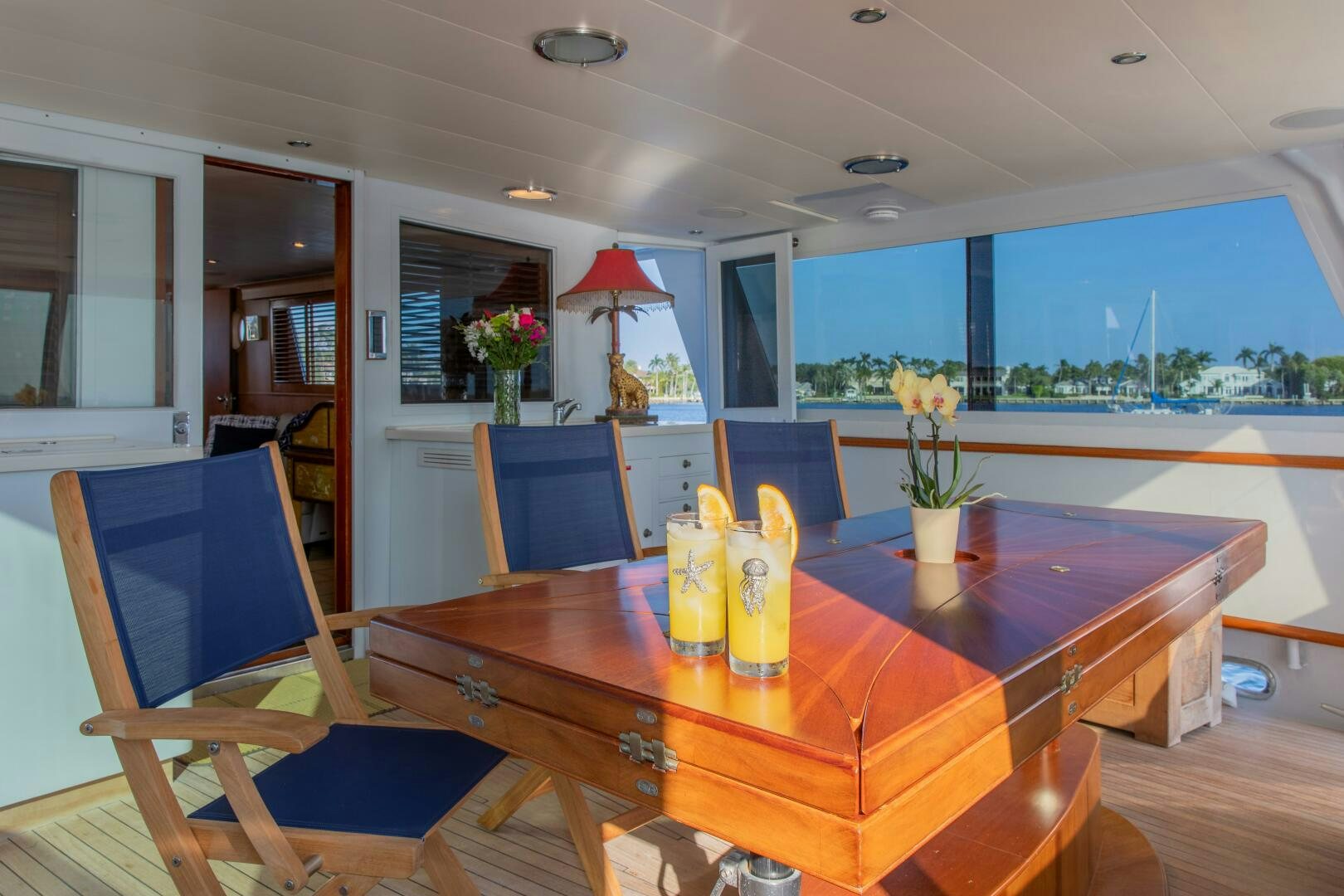 a dining table with chairs and a red umbrella aboard KOALA Yacht for Sale