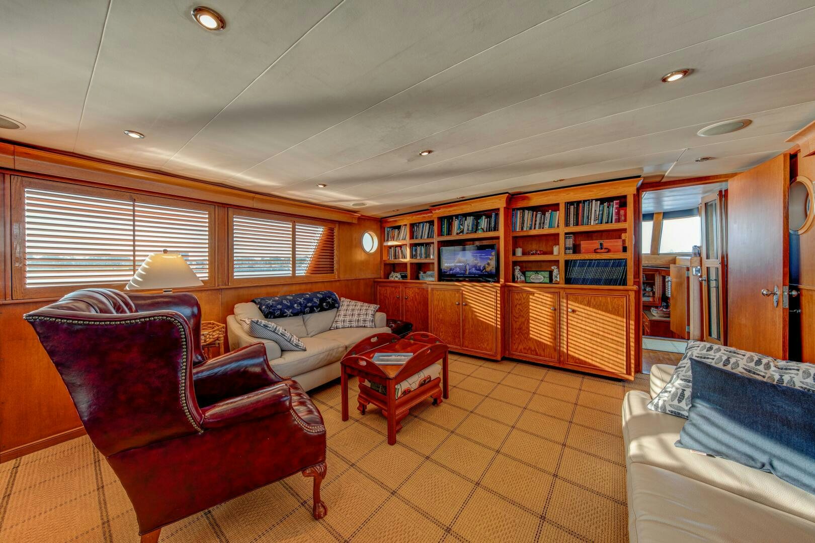 a living room with a couch and a book shelf aboard KOALA Yacht for Sale