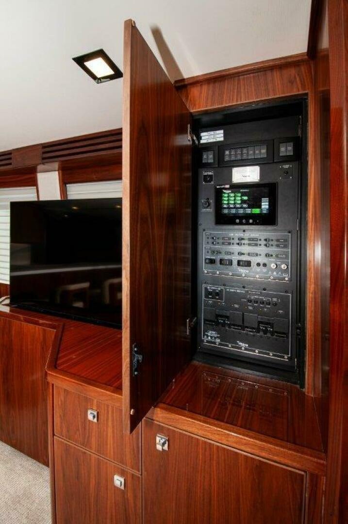 a wood cabinet with a clock aboard FLEUR DE LIS Yacht for Sale