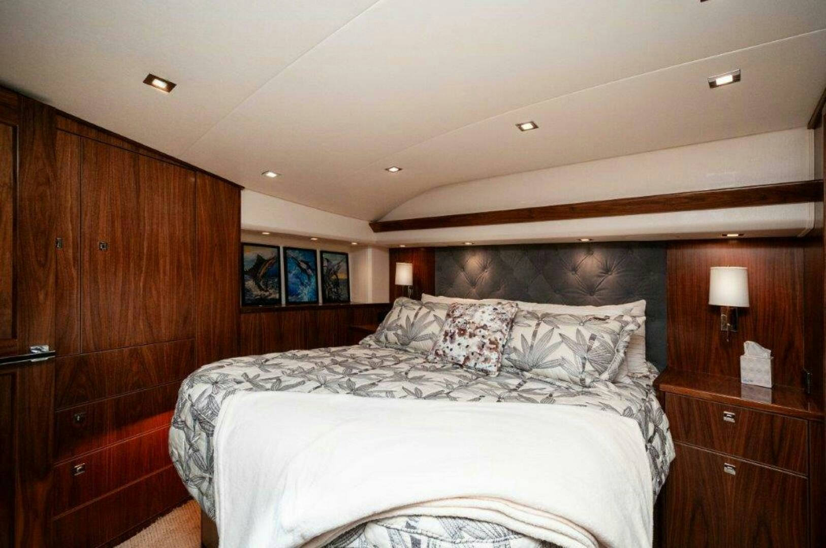 a bedroom with a bed and a wood cabinet aboard FLEUR DE LIS Yacht for Sale