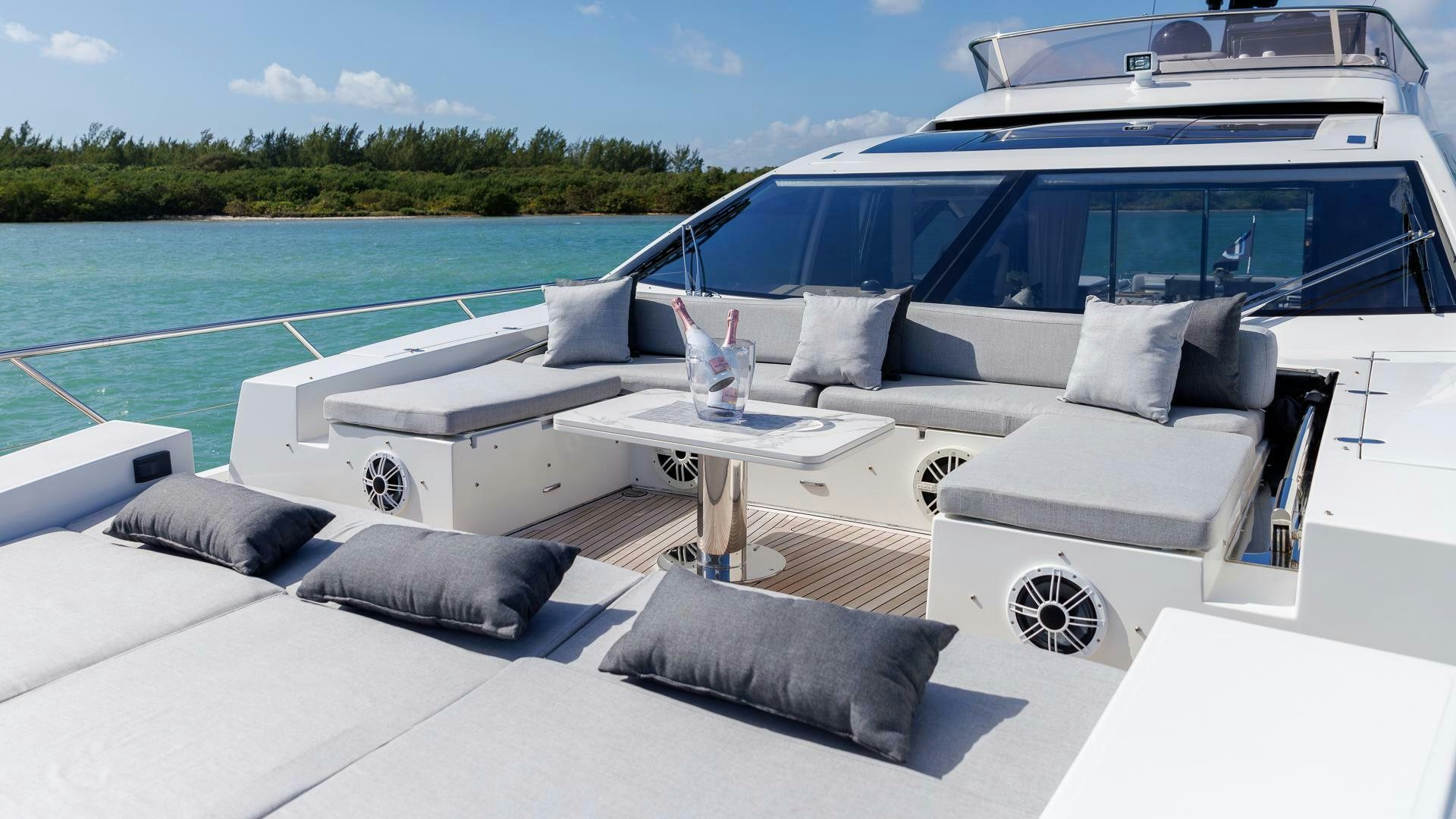 a white couch and a table on a boat in the water aboard DEVENZO Yacht for Sale