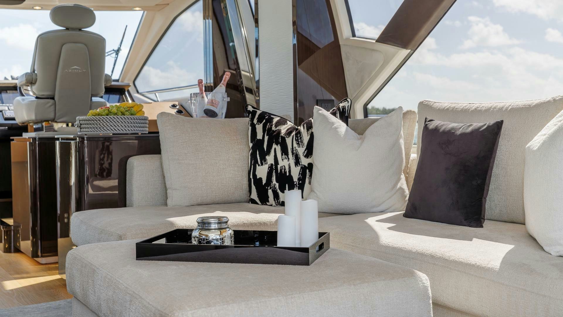 a white couch with pillows and a table with a white pillow on it aboard DEVENZO Yacht for Sale