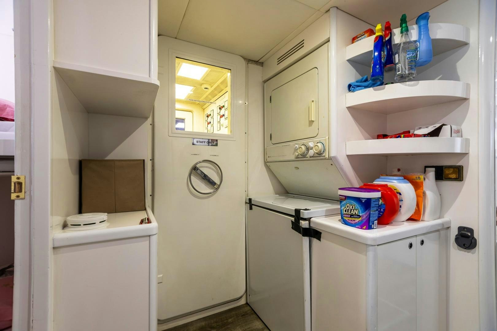 a white cabinet with a sink and a shelf with cleaning supplies aboard GRANDEUR Yacht for Sale