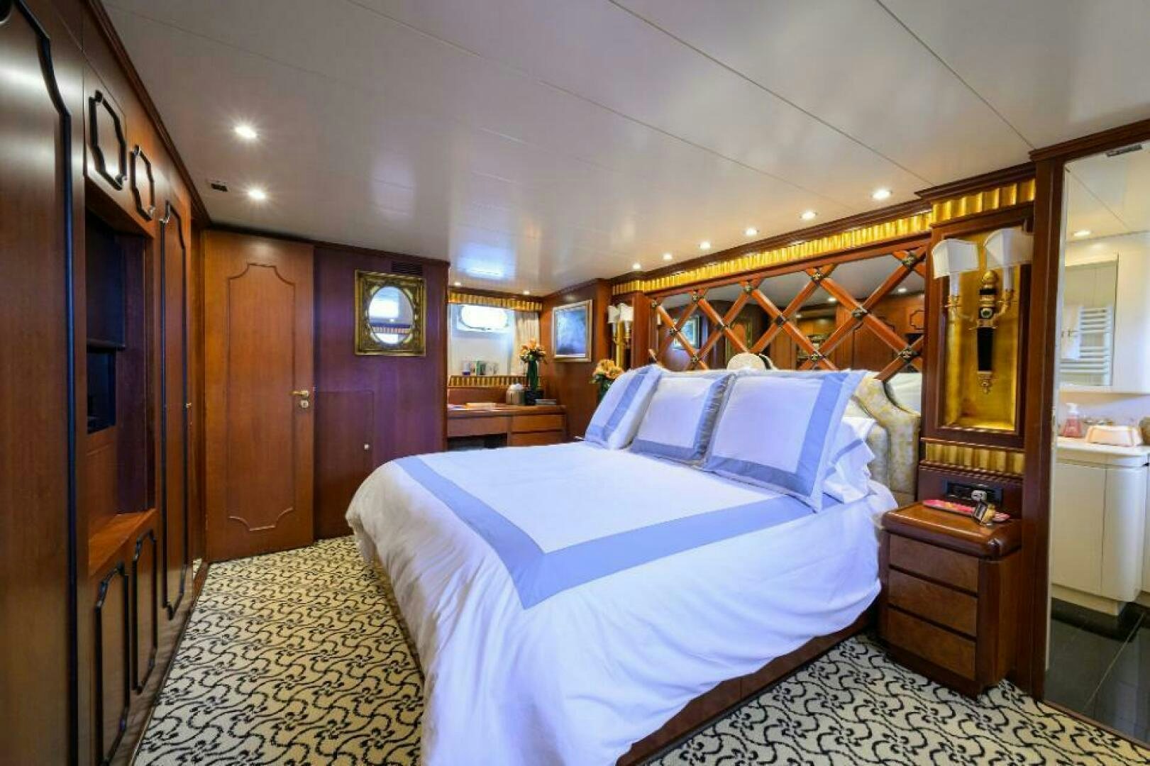 a bedroom with a bed and a mirror aboard CIPANGO Yacht for Sale