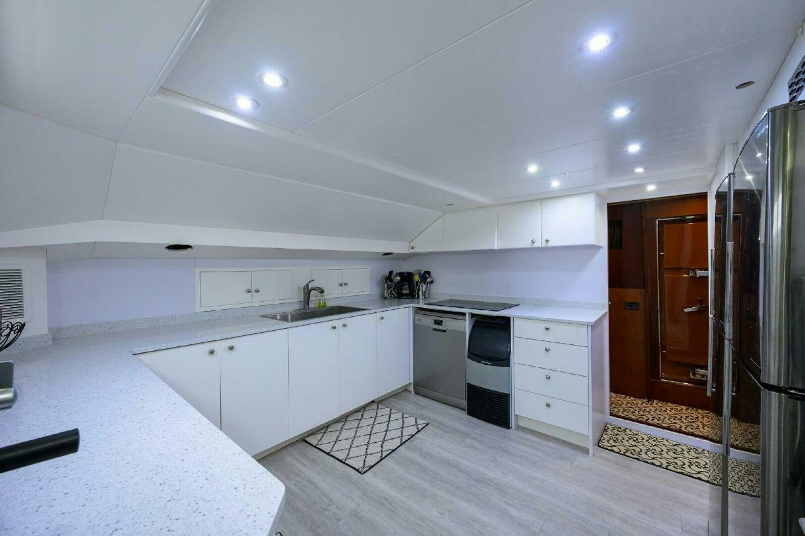 a kitchen with white cabinets aboard CIPANGO Yacht for Sale