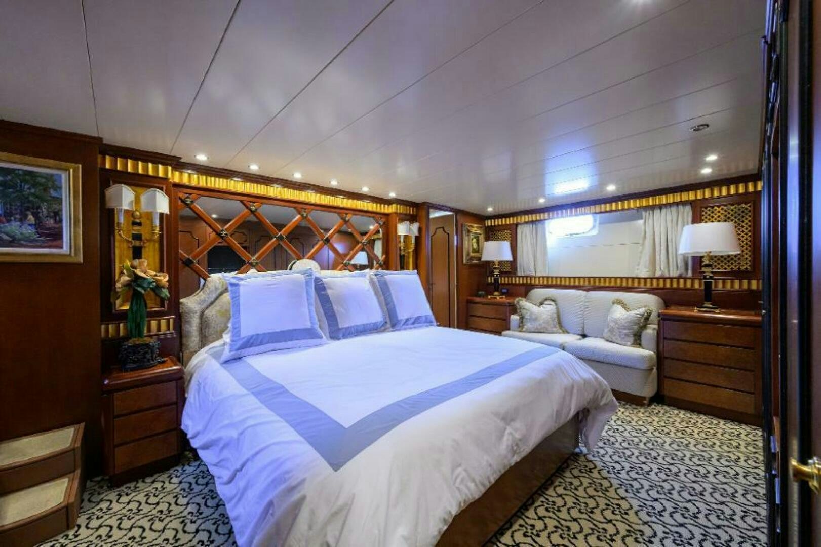 a bedroom with a bed and a couch aboard CIPANGO Yacht for Sale