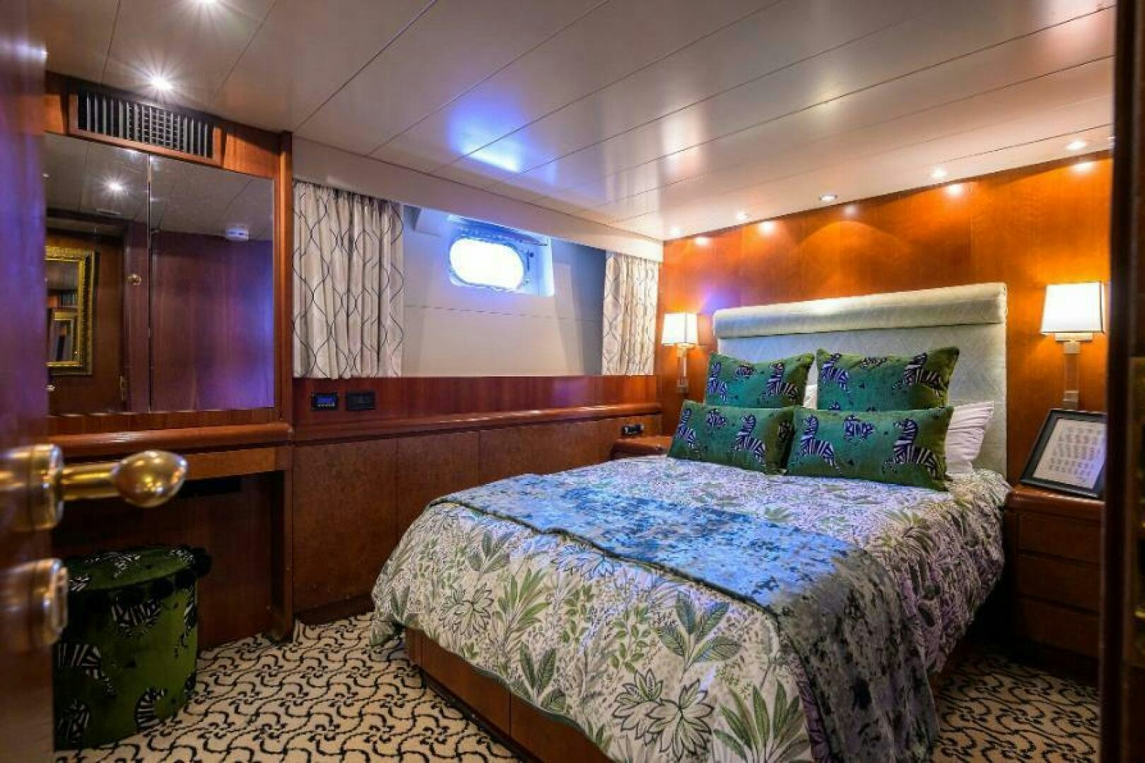 a bedroom with a bed and a dresser aboard CIPANGO Yacht for Sale