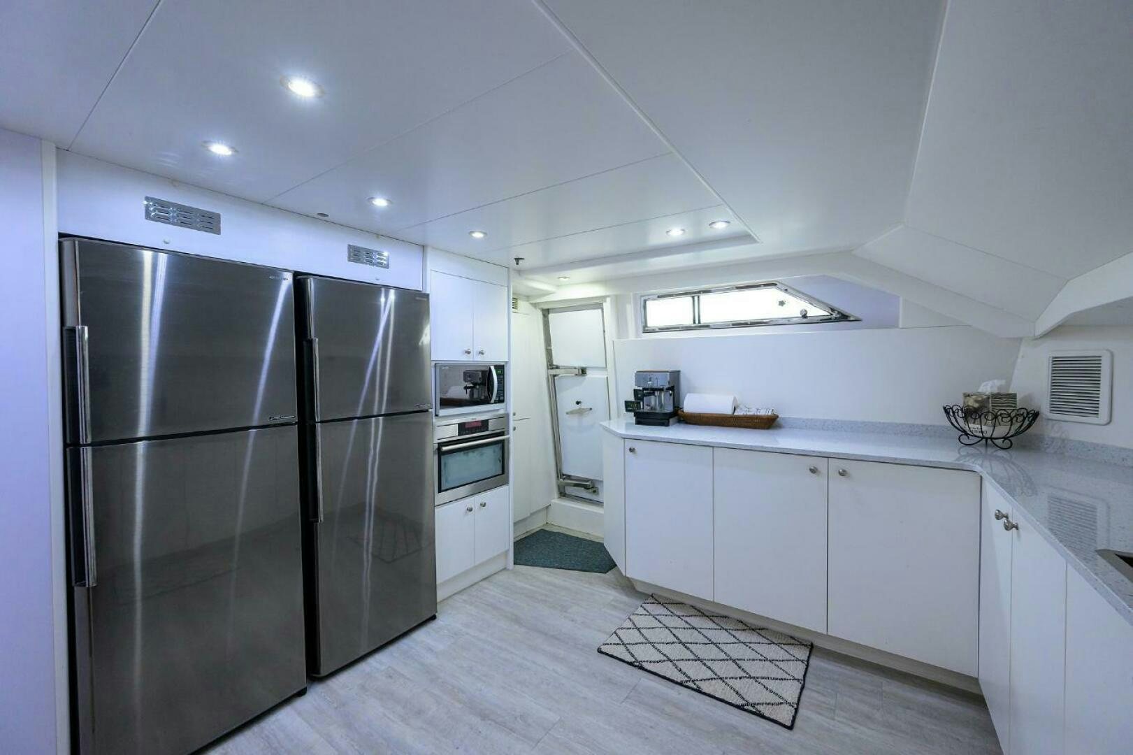 a kitchen with white cabinets aboard CIPANGO Yacht for Sale