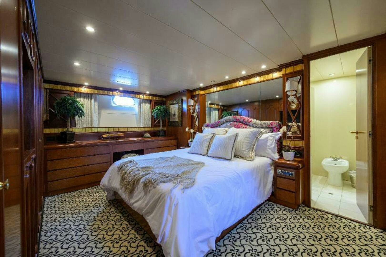 a bedroom with a bed and a mirror aboard CIPANGO Yacht for Sale