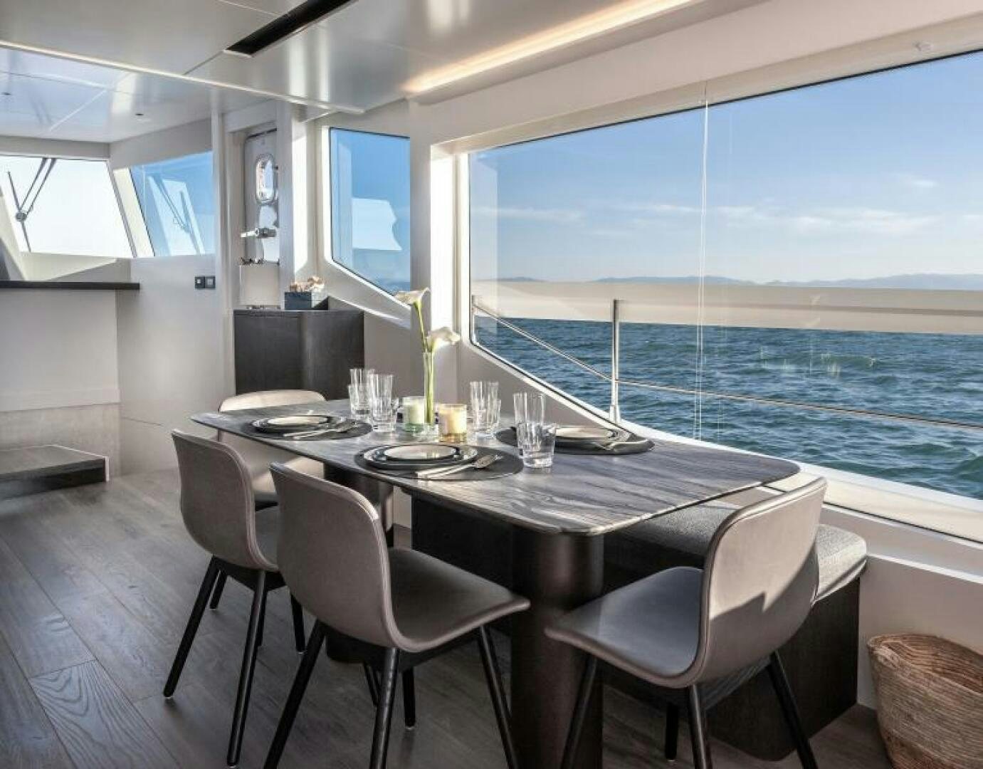 a table with chairs and a view of the ocean aboard NUMARINE 22XP/07 Yacht for Sale