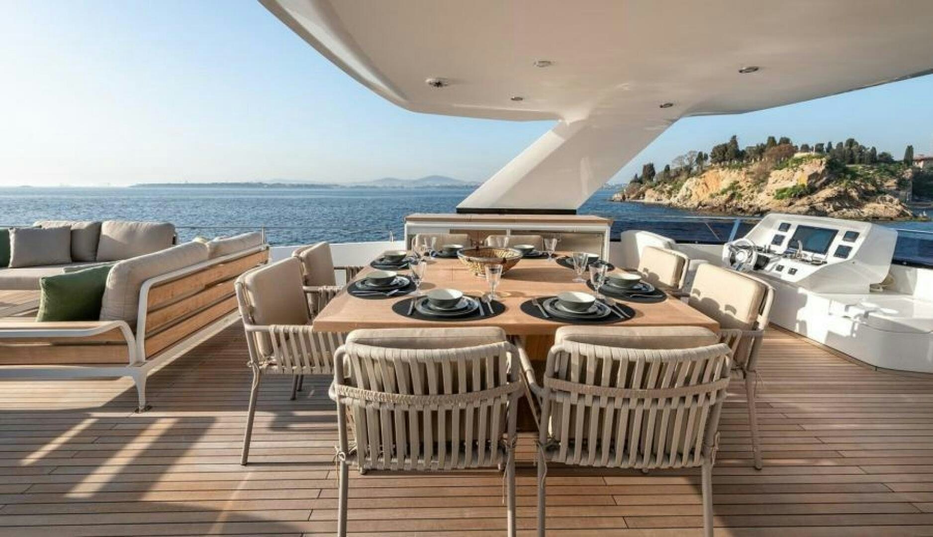 a large dining table on a deck overlooking the ocean aboard NUMARINE 22XP/07 Yacht for Sale