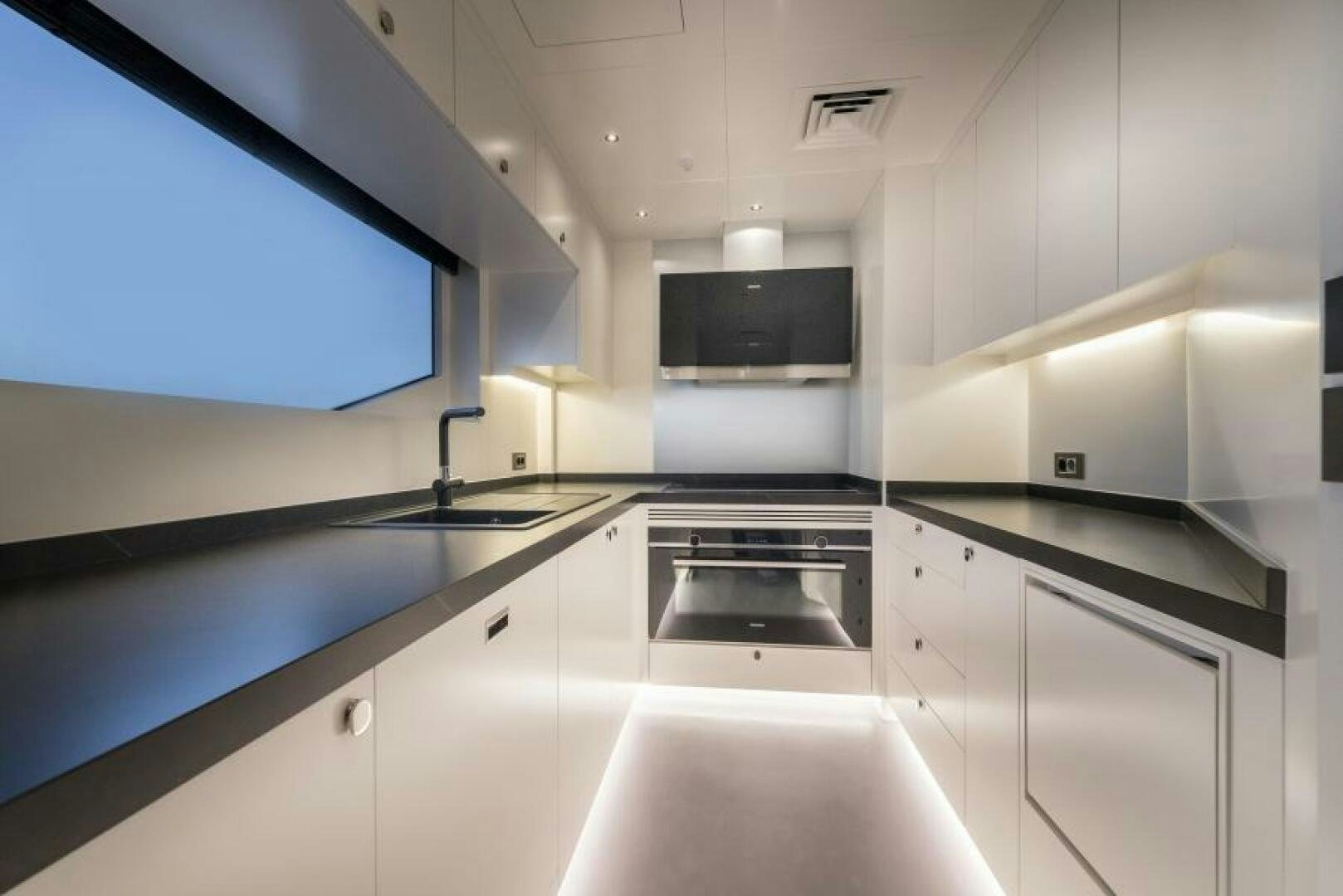 a kitchen with white cabinets aboard NUMARINE 22XP/07 Yacht for Sale