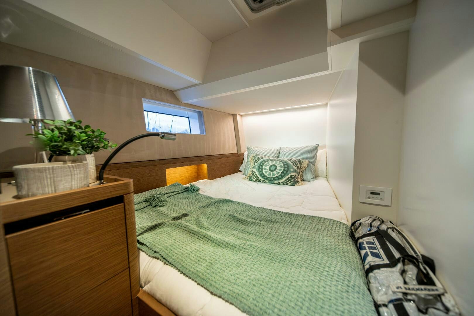 a bed with a green blanket aboard FORTITUDE Yacht for Sale