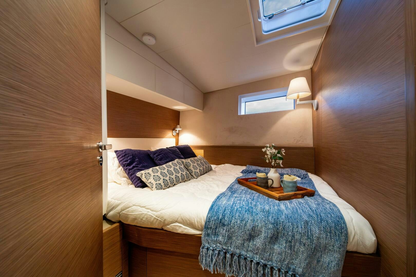 a bed with a blue blanket aboard FORTITUDE Yacht for Sale