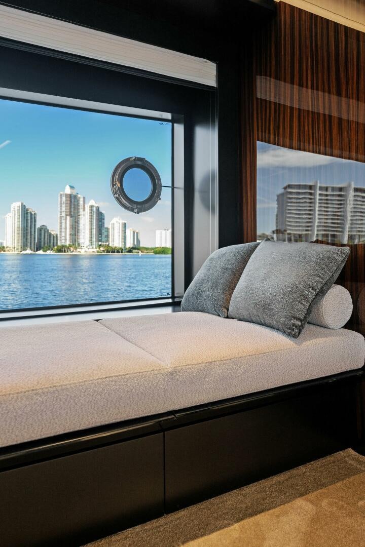 a bed with a large window overlooking a city aboard CORSARO SUPER Yacht for Sale