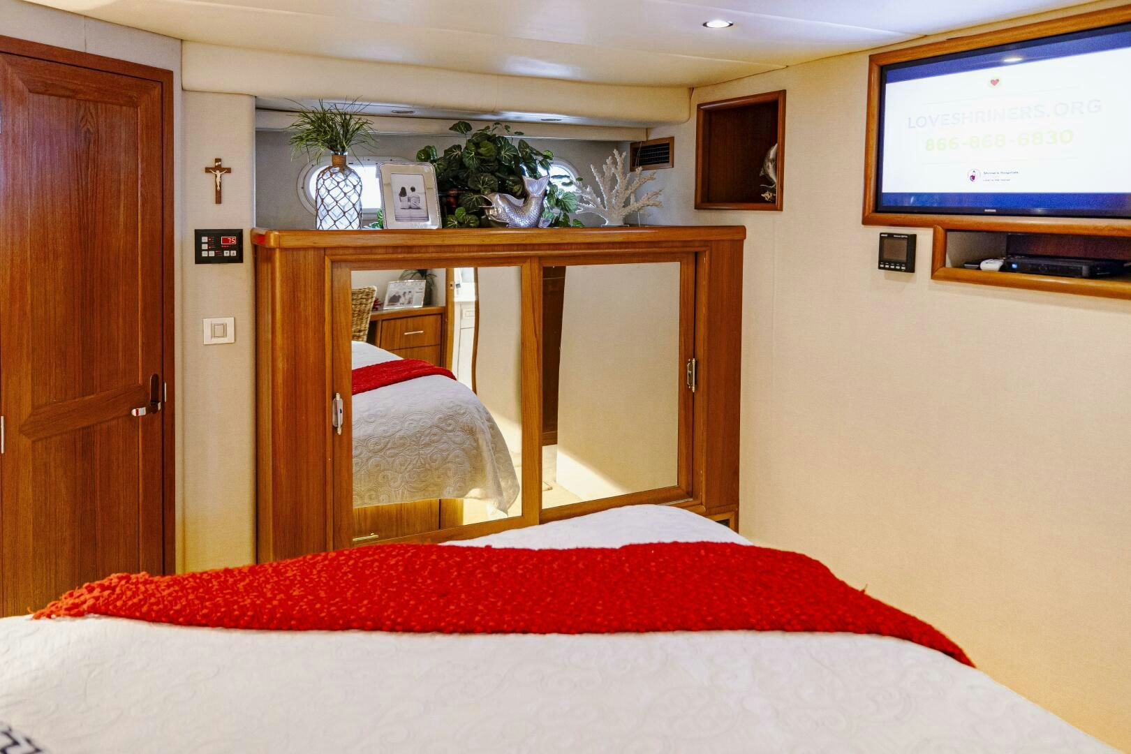 a bedroom with a bed and a television aboard LADY LETICIA V Yacht for Sale