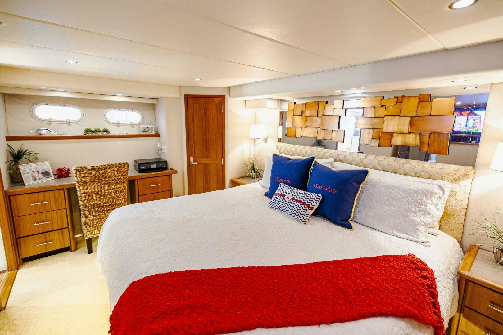a large bed with blue and red pillows aboard LADY LETICIA V Yacht for Sale