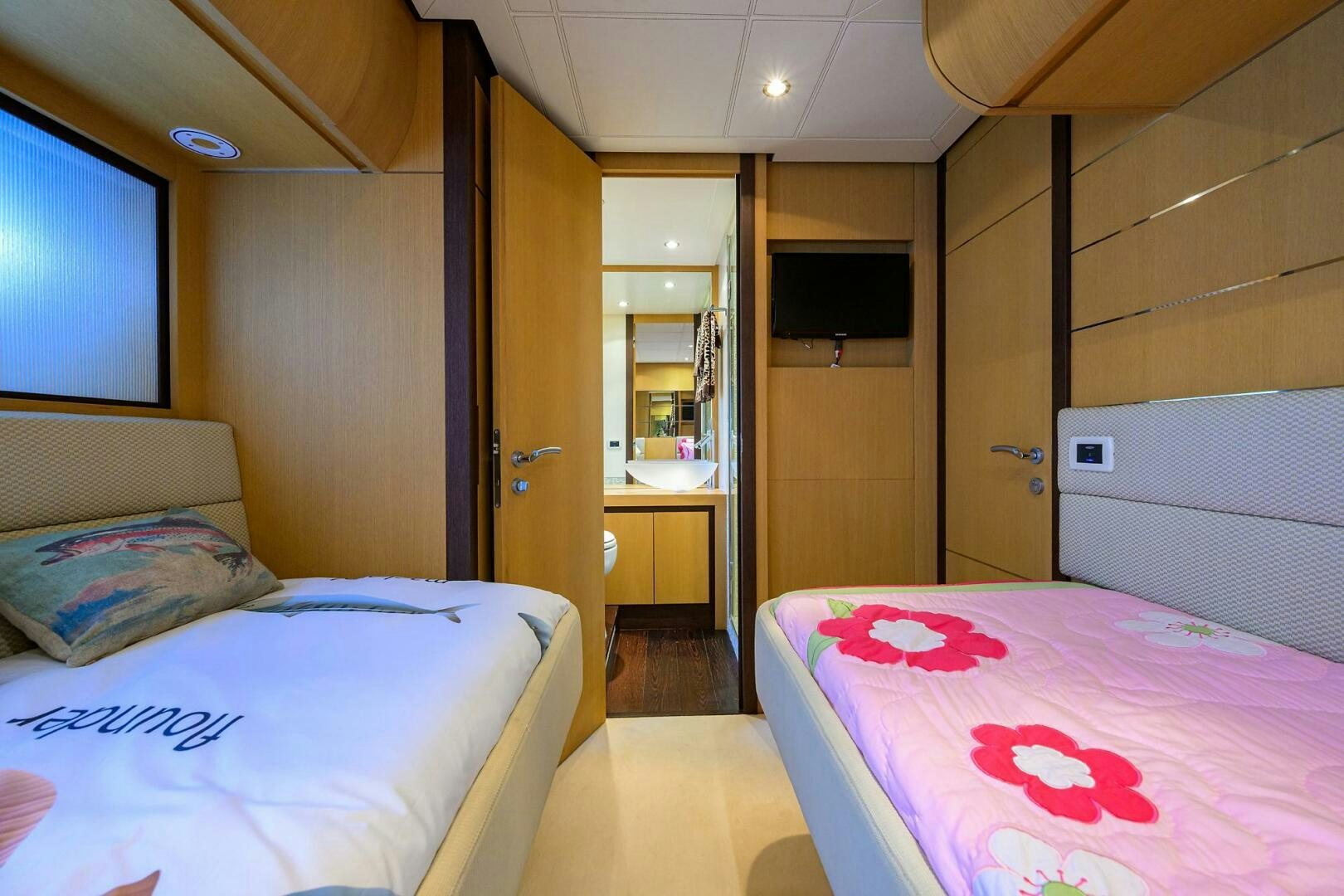 a room with a bed and a television aboard MIURA Yacht for Sale