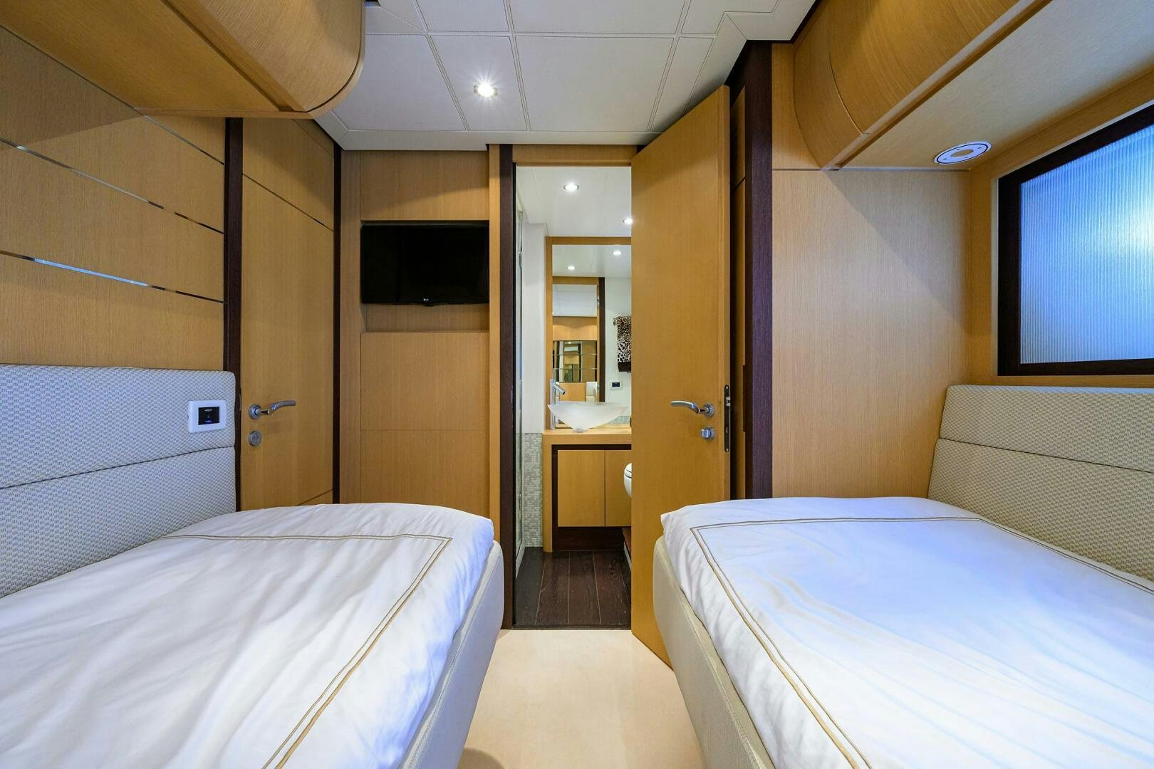 a room with beds and a tv aboard MIURA Yacht for Sale