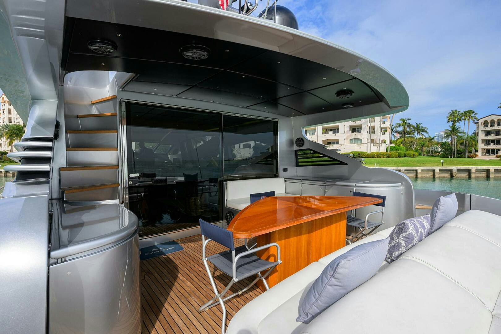 a large open air space with a table and chairs and a large building aboard MIURA Yacht for Sale