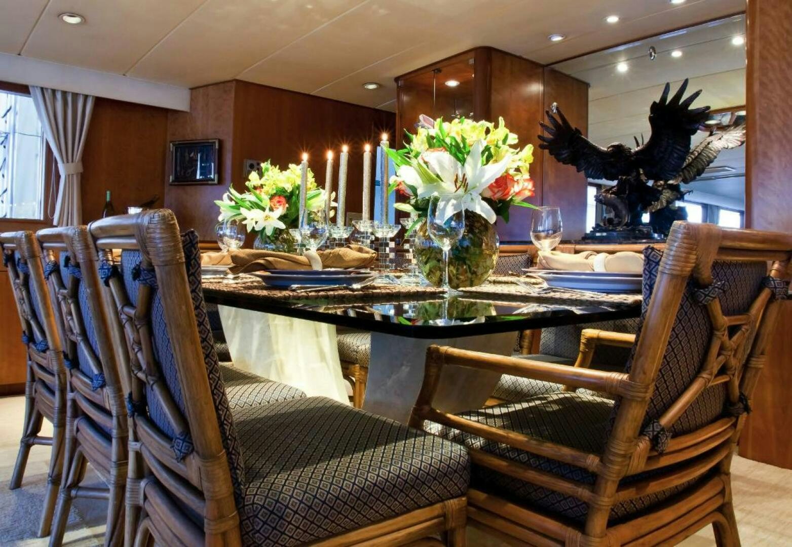 a dining room table with chairs and a vase of flowers on it aboard GOLDEN EAGLE Yacht for Sale
