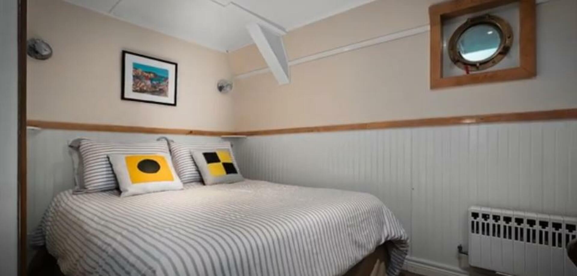 a bed with a white comforter and a mirror above it aboard PRESCOTONT Yacht for Sale