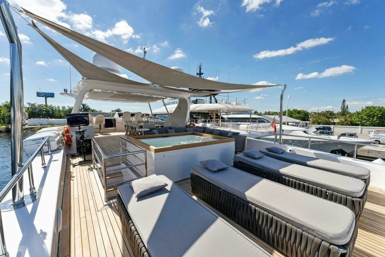 a deck with a roof and a building with a roof and a blue sky with clouds aboard PRINCESS LONA Yacht for Sale