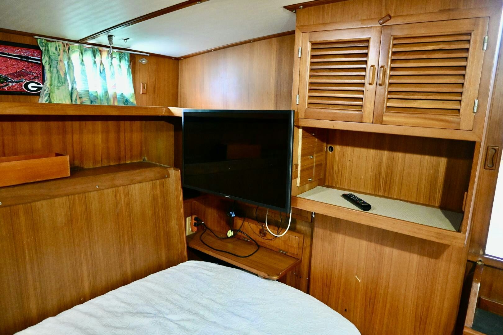 a bedroom with a tv and a bed aboard LITTLE BAYOU Yacht for Sale