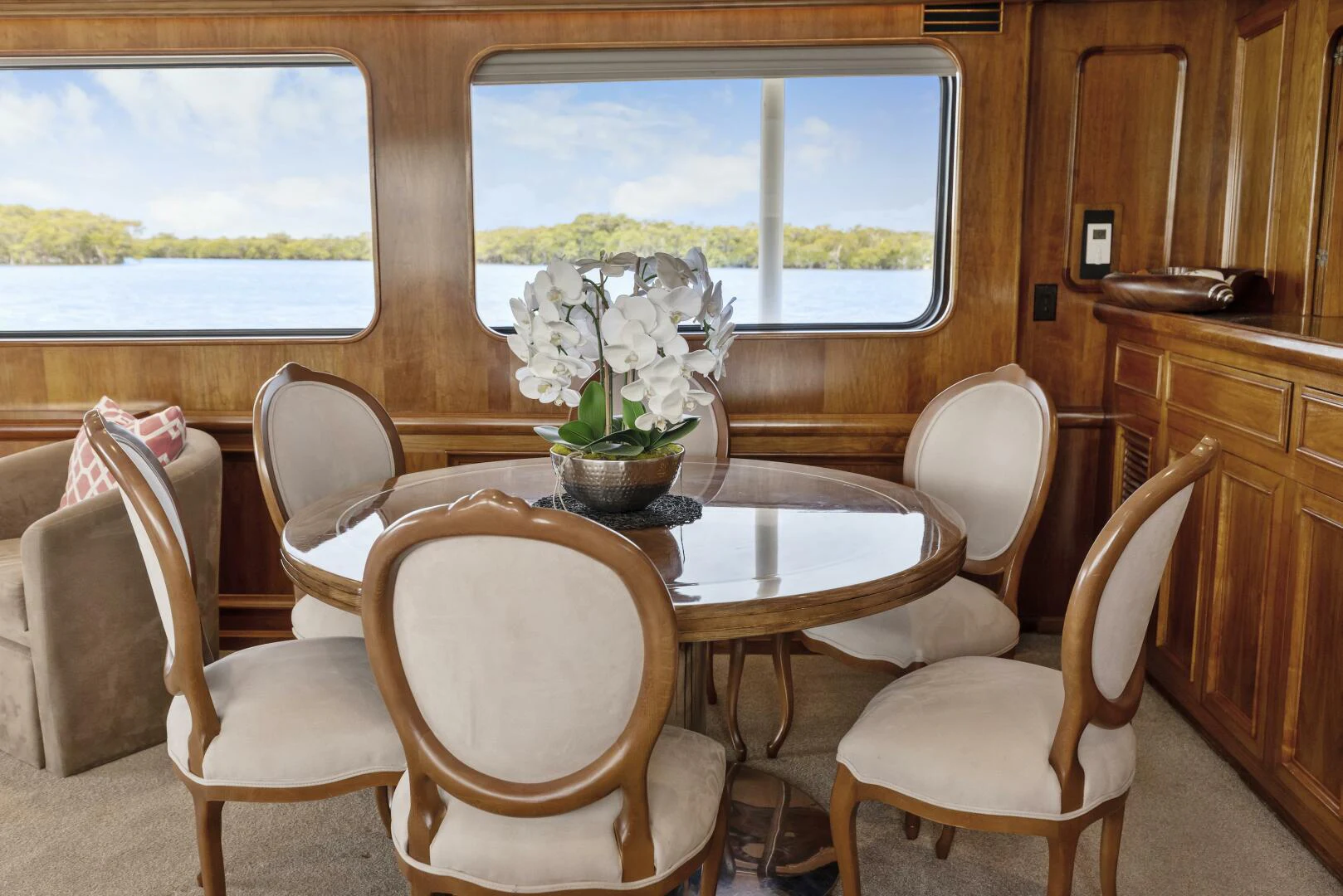 a dining table and chairs in a room with a window aboard HUNTRESS Yacht for Sale